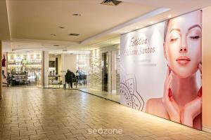 a store hallway with a large billboard of a woman at Studios modernos à beira-mar - Jurerê Beach Village JBVTOP in Florianópolis