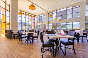a restaurant with tables and chairs and windows at Studios modernos à beira-mar - Jurerê Beach Village JBVTOP in Florianópolis +281 photos