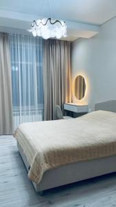 a bedroom with a large bed and a mirror at Новая Евродвушка&Комфорт КЖБИ in Kostanay