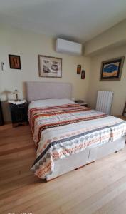a bedroom with a bed with a blanket on it at Elaine's Athens Riviera Studios in Athens