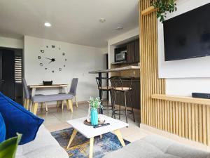 a living room with a couch and a clock on the wall at Apartamento familiar en Armenia Q in Armenia
