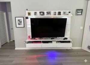 a flat screen tv sitting on a white entertainment center at Purple Prairie Pad in Buda
