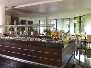 a buffet line in a hotel with food on it at Mercure Hotel Hagen in Hagen