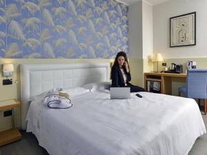 Un pat sau paturi într-o cameră la Mercure Reggio Emilia Centro Astoria +78 fotografii