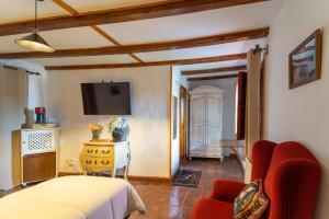 Un dormitorio con una cama y un televisor en la pared. en Hospedium Hostería Rural Isabel La Católica, en Aranda de Duero