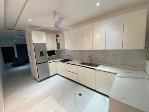 a kitchen with white cabinets and a ceiling fan at 2BR Ultra Modern Apartment in Gbawe in Gbawe