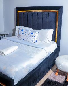 a bed with a blue headboard and pillows on it at Greatwall in Athi River