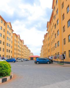 a parking lot with cars parked in front of tall buildings at Greatwall in Athi River