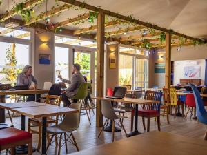 two people sitting at tables in a restaurant at greet Hotel Marseille Provence Aéroport in Vitrolles