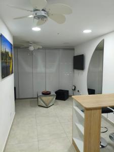 a living room with a ceiling fan and a table at Comfort and convenience for your family stay in Ibagué