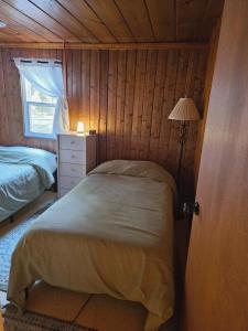 Ένα ή περισσότερα κρεβάτια σε δωμάτιο στο Rustic-Chic 2bdr Pet Friendly Log Cabin, Steps to Lake Huron
