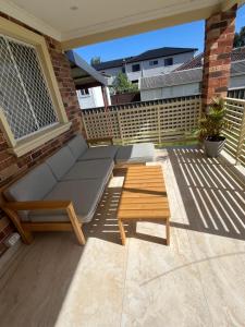 a patio with a couch and a coffee table at Double room with shared bathoom in Auburn