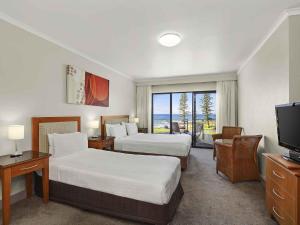 une chambre d'hôtel avec deux lits et une télévision dans l'établissement ibis Styles Port Macquarie, à Port Macquarie 101 autres photos