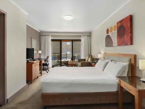 une chambre d'hôtel avec un lit et un salon dans l'établissement ibis Styles Port Macquarie, à Port Macquarie