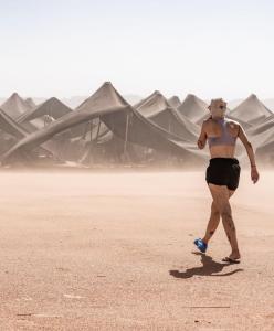 ein Mann im Bikini, der in der Wüste läuft in der Unterkunft Camp azawan hananich 