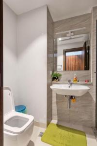 a bathroom with a sink and a toilet and a mirror at EasyStay Apartments in Ogere