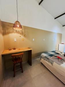 a bedroom with a desk next to a bed at Pousada Nascente do Sol in Ilha de Boipeba