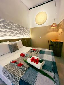 a bedroom with a bed with red flowers on it at Pousada Nascente do Sol in Ilha de Boipeba