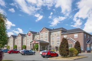 a large building with cars parked in a parking lot at Best Western Plus Fredericton Hotel & Suites in Fredericton