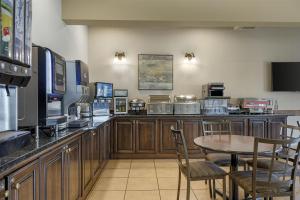 フレデリクトンにあるBest Western Plus Fredericton Hotel & Suitesのテーブルと椅子のあるバーがあるレストラン