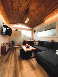 a living room with a couch and a table at Charmful Beach Cabin - Sauna - Private Hot Tub in Wapnica
