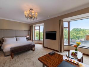 a hotel room with a bed and a television at Sofitel Hangzhou Westlake - Few steps to West Lake, with panoramic lake view terrace in Hangzhou