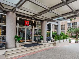 a store front of a building with potted plants at ibis Guarulhos Aeroporto in Guarulhos