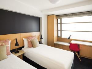 une chambre d'hôtel avec deux lits et une fenêtre dans l'établissement ibis Sydney World Square, à Sydney