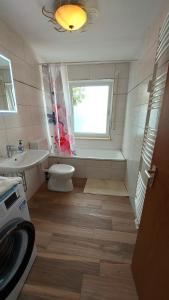 a bathroom with a toilet and a sink and a window at schöne Wohnung mit Balkon, zentrumnah in Marktoberdorf