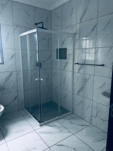 a shower with a glass door in a bathroom at Swakop Coastal Haven in Swakopmund