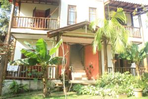 a house with a palm tree in front of it at Pousada Ponte Branca in Paraty