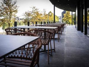 una fila de mesas y sillas en un restaurante en Mercure Namur Hotel, en Namur