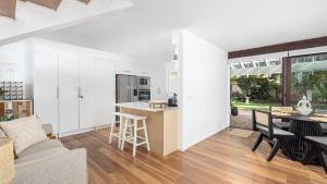 une cuisine et un salon avec des murs blancs et une table dans l'établissement Solace by the Bay, à Corlette 17 autres photos