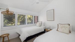Cette chambre blanche dispose de 2 lits et de 2 fenêtres. dans l'établissement Solace by the Bay, à Corlette