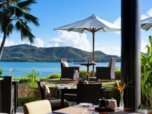 a restaurant with a view of the ocean at Raffles Seychelles in Baie Sainte Anne