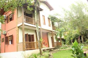 a building with balconies and trees in front of it at Pousada Ponte Branca in Paraty