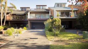 une grande maison avec une allée devant dans l'établissement Solace by the Bay, à Corlette