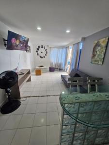 Una sala de estar con un sofá y un reloj en la pared. en Apartamentos Vacacionales Cartagena, en Cartagena de Indias