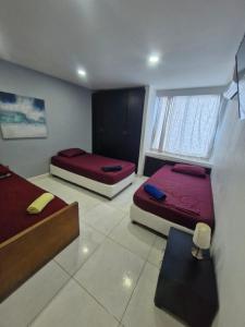 una habitación con dos camas y una ventana en Apartamentos Vacacionales Cartagena, en Cartagena de Indias 46 fotos más