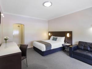 pokój hotelowy z łóżkiem i kanapą w obiekcie Mercure Wagga Wagga w mieście Wagga Wagga