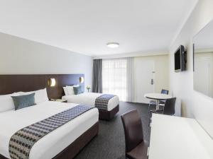 pokój hotelowy z dwoma łóżkami i stołem w obiekcie Mercure Wagga Wagga w mieście Wagga Wagga