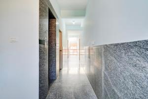 a hallway with marble tiles on the walls at Super Collection O Uttarahalli in Bangalore