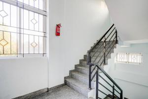 a staircase in a building with a red sign on the wall at Super Collection O Uttarahalli in Bangalore +44 photos