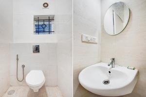 a bathroom with a sink and a toilet and a mirror at Super Collection O Uttarahalli in Bangalore