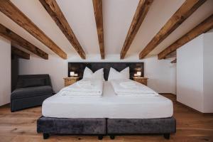 Un dormitorio con una gran cama blanca y una silla. en Casa Relajante, en Teruel