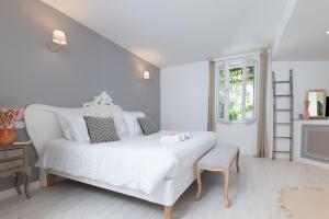 a white bedroom with a white bed and a chair at Azurenting - Villa 5 chambres - Juan-les-pins in Antibes