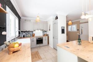 a kitchen with white cabinets and a bowl of fruit on a counter at Azurenting - Villa 5 chambres - Juan-les-pins in Antibes