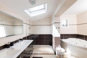 a bathroom with a large tub and a sink and a bath tub at Azurenting - Villa 5 chambres - Juan-les-pins in Antibes