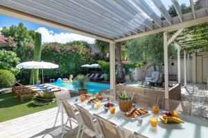 a patio with a table with food and a pool at Azurenting - Villa 5 chambres - Juan-les-pins in Antibes +25 photos