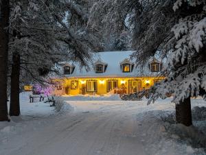 een huis in de sneeuw met lichten aan bij La Tremblante in Mont-Tremblant